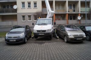 Wynajem podnośnika koszowego, zwyżki Kraków Mała zwyżka na zatłoczonym parkingu.